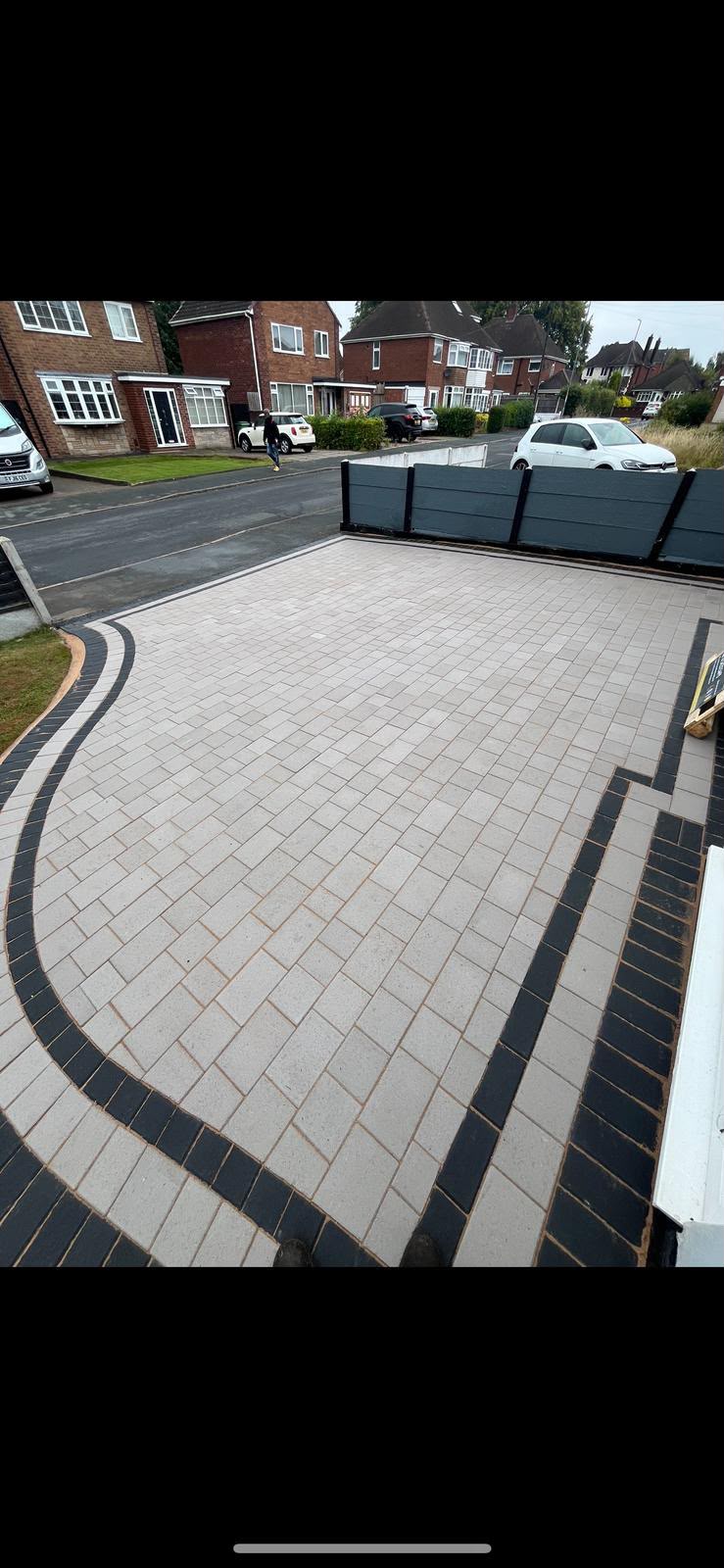 Block paving driveway detail showing tight herringbone joints and crisp charcoal edging